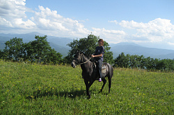Эта девушка на лошади туристка конного маршрута Верхом в край гор и водопадов