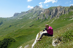 Девушка в горах с фотоаппаратом, маршрут 30 через горы к морю