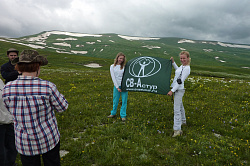 Эти девушки с флагом в горах на юге России туристки маршрута Знаменитая "Тридцатка" - легендарный маршрут 30. Девушки любят фотографироваться с флагом в красивых местах этого маршрута и на природе с видами гор и снежников на фоне яркой зелени.
