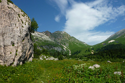 Горный пейзаж фото с маршрута  Знаменитая Тридцатка - легендарный маршрут 30. Этот красивый горный пейзаж снят на Фиштинской поляне, слева скала-валун Фиштёнок, прямо Фишт-Оштеновский горный перевал.