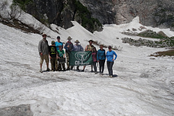 Туристы на леднике в горах в походе на маршруте 30 через горы к морю